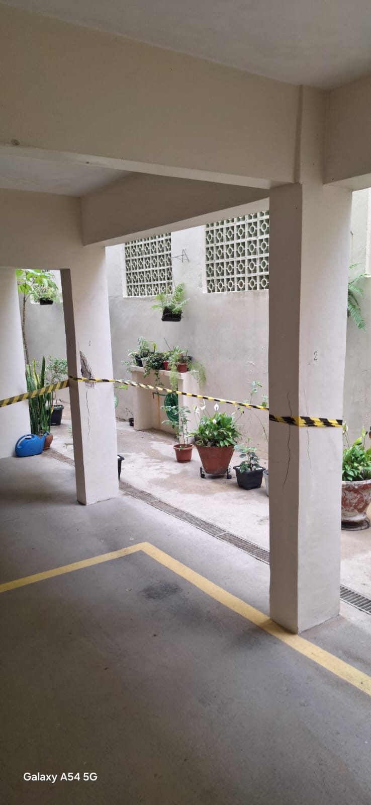 Pilar de concreto com armaduras expostas em tratamento para recuperação estrutural