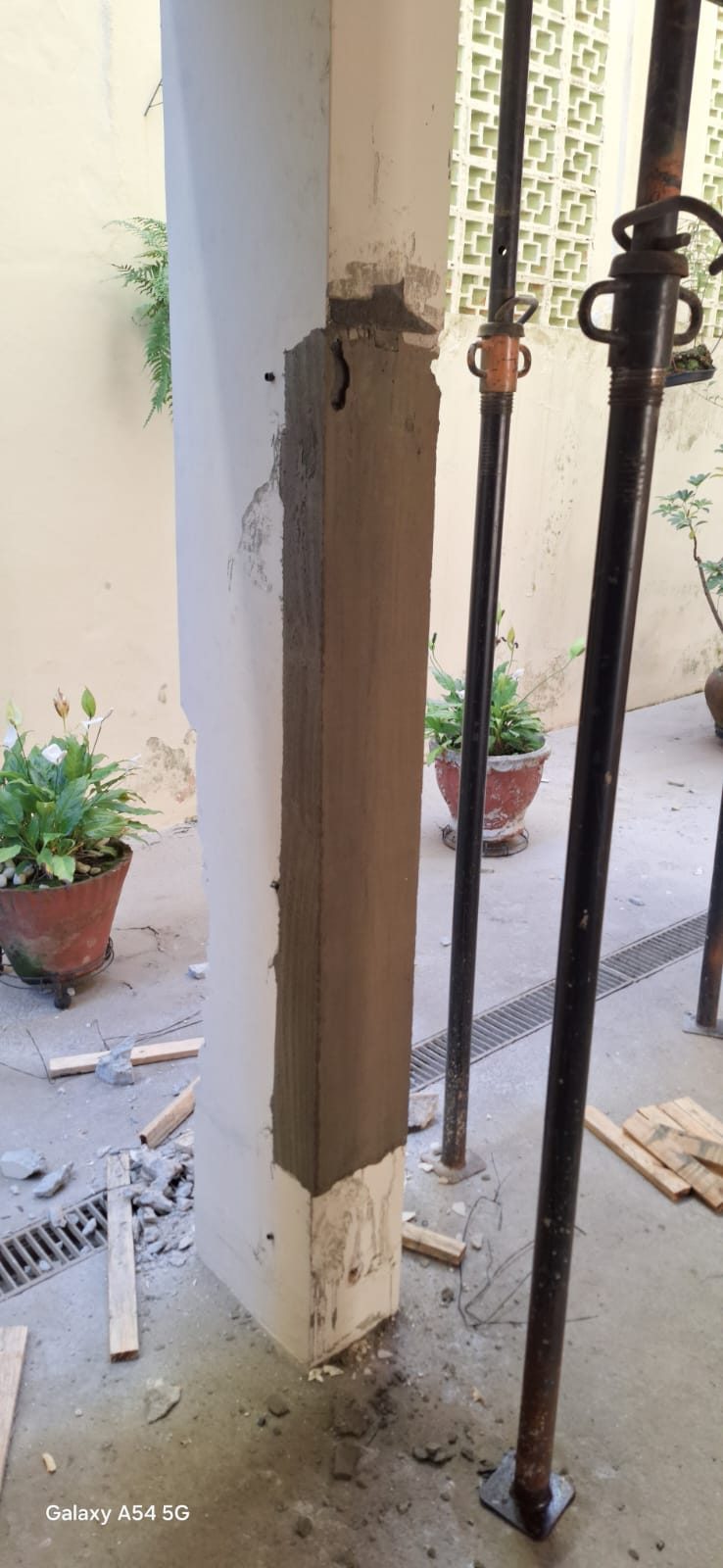 Pilar de concreto recomposto após recuperação estrutural em obra real